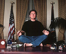Martin Sheen on a desk looking silly